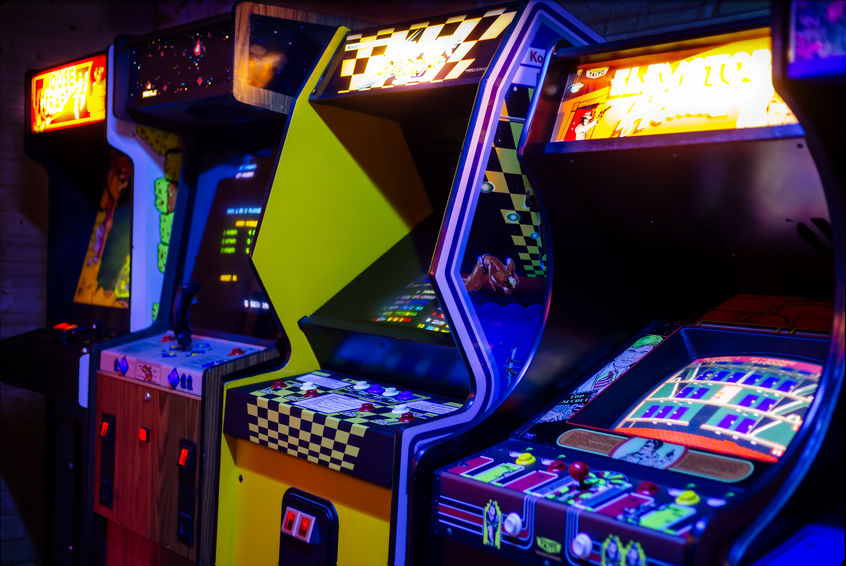 Row of Old Arcade Video Games with Shining Displays in a Dark Gaming Room